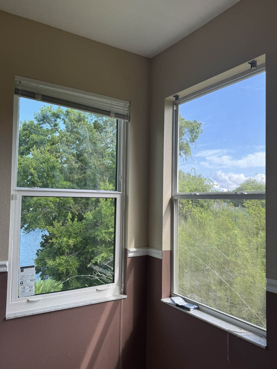 replace home windows Exterior of a modern white home with black trim and large picture windows installed, viewed from the front entry.