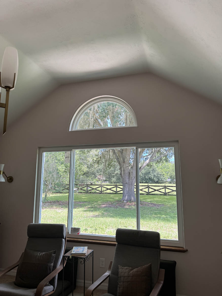 replace home windows Exterior of a modern white home with black trim and large picture windows installed, viewed from the front entry.