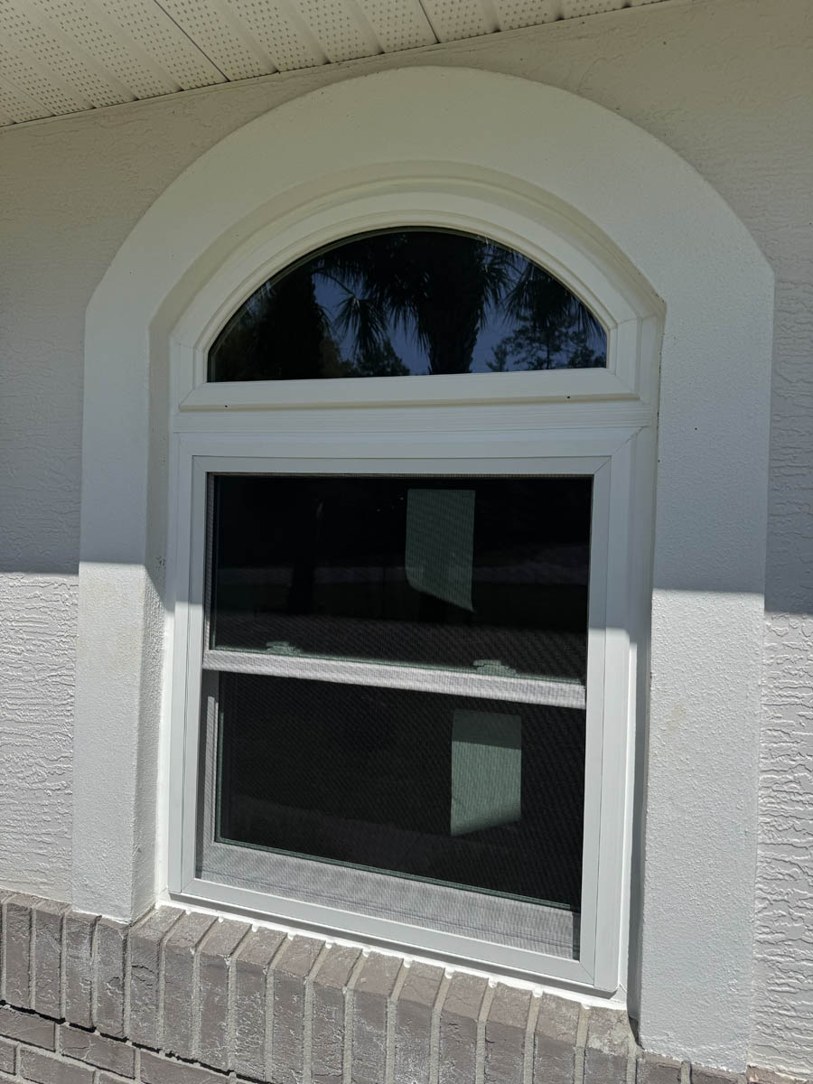 window replacement for homes Exterior of a modern white home with black trim and large picture windows installed, viewed from the front entry.