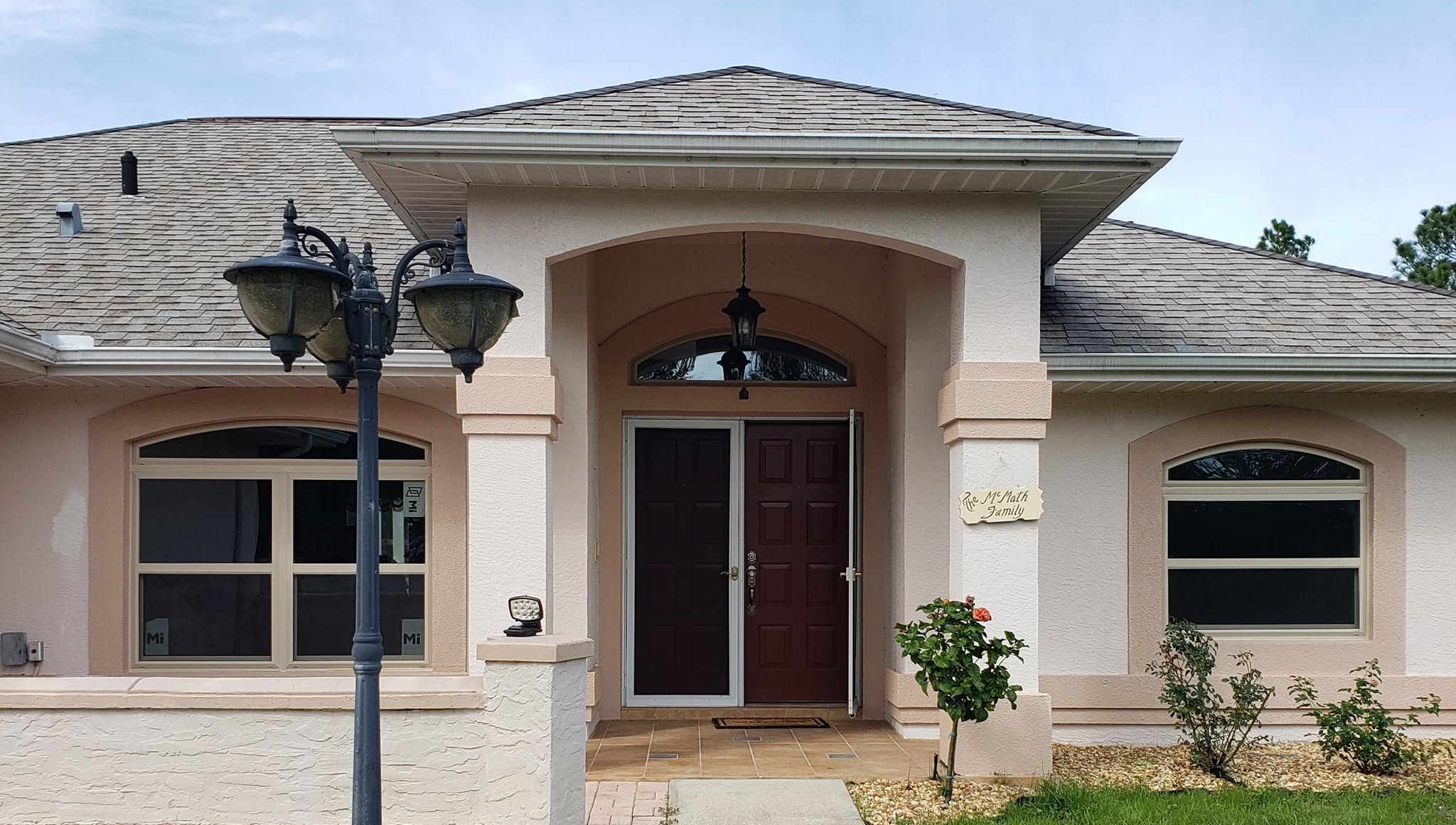 Double Front Entry Doors With Storm Door and Transom Dark double front entry doors with storm door, arched transom window, and matching home windows on a Florida house.