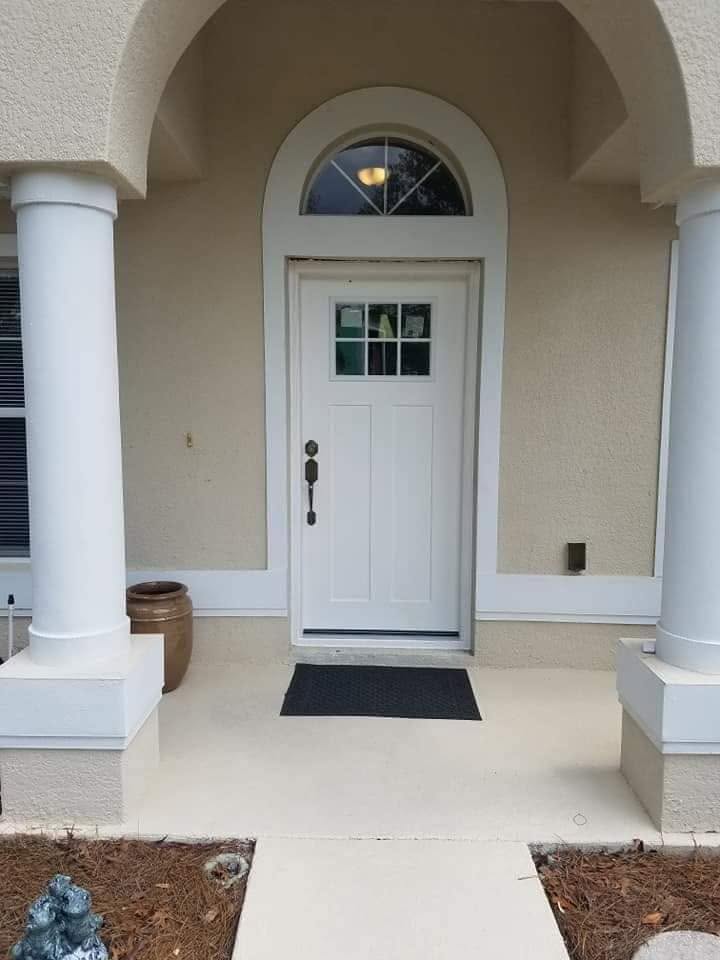 White Fiberglass Entry Door With Glass Window White fiberglass entry door with upper glass window and arched transom installed under a covered front entryway.