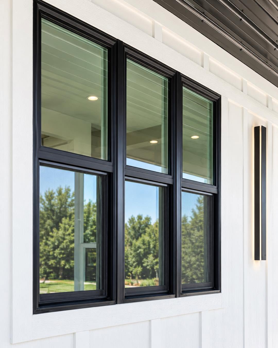 Black Energy Efficient Windows on a Modern Home Three black-framed energy efficient windows installed against white exterior siding on a modern home.