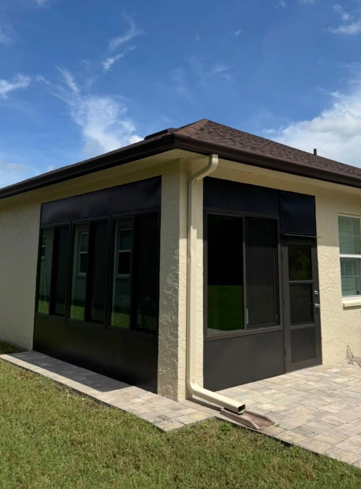 Dark-Framed-Screen-Room-Conversion-crop Screened in patio completed with large windows by Tropical Window as part of a screen room conversion.